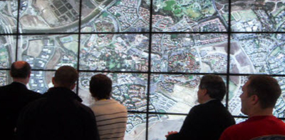 people standing in front of a hiperwall install on a wall